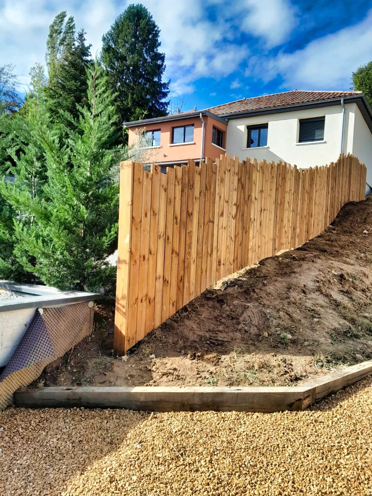 Clôture en bois posée sur un terrain en pente terrassé à Dardilly