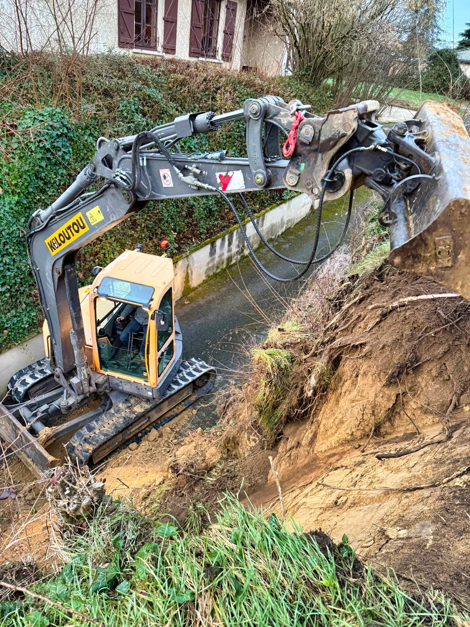 Pelleteuse réalisant un terrassement le long d’un mur de soutènement à Dardilly
