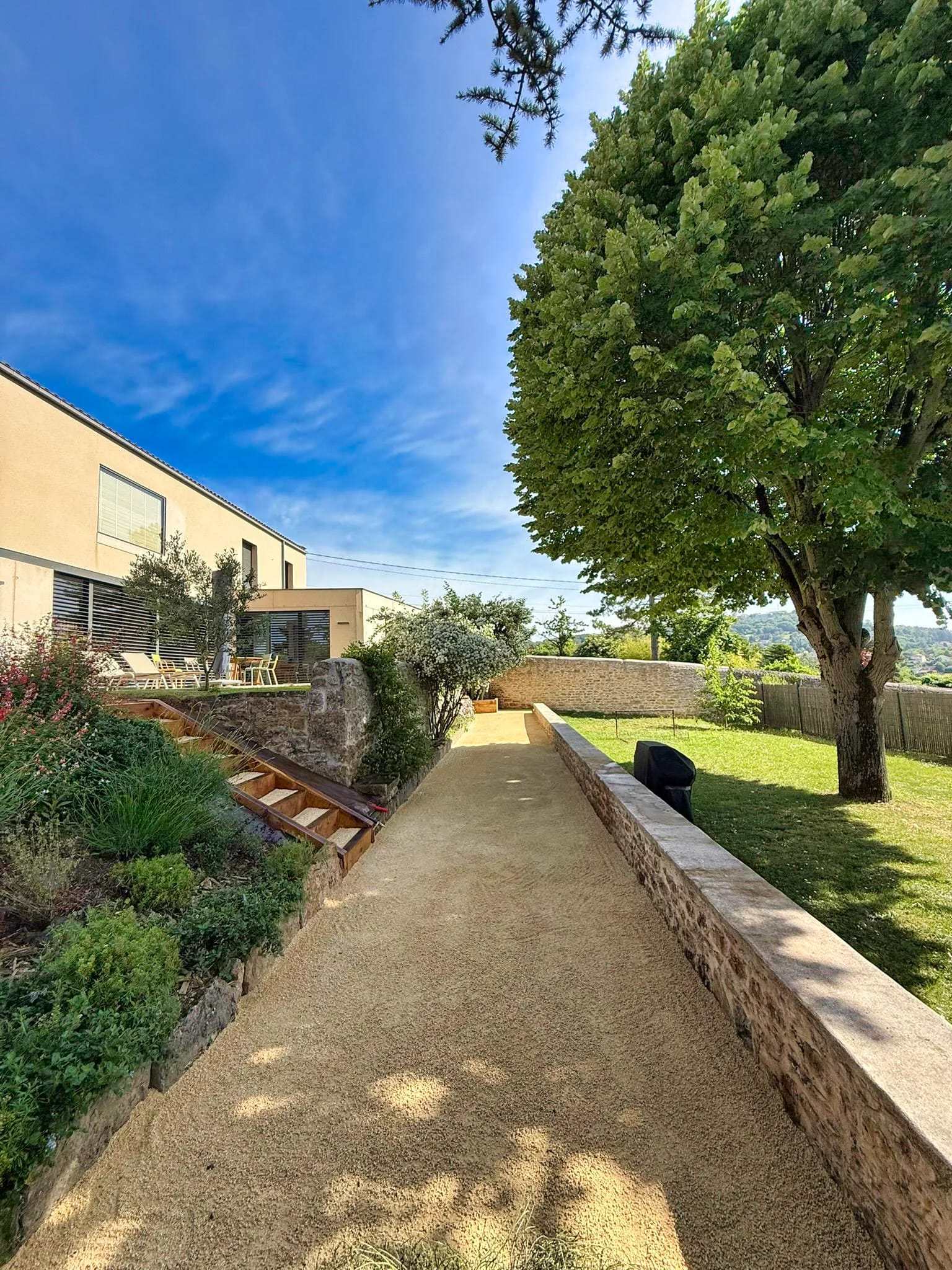 Allée pavée traversant un jardin contemporain devant une maison moderne à Écully